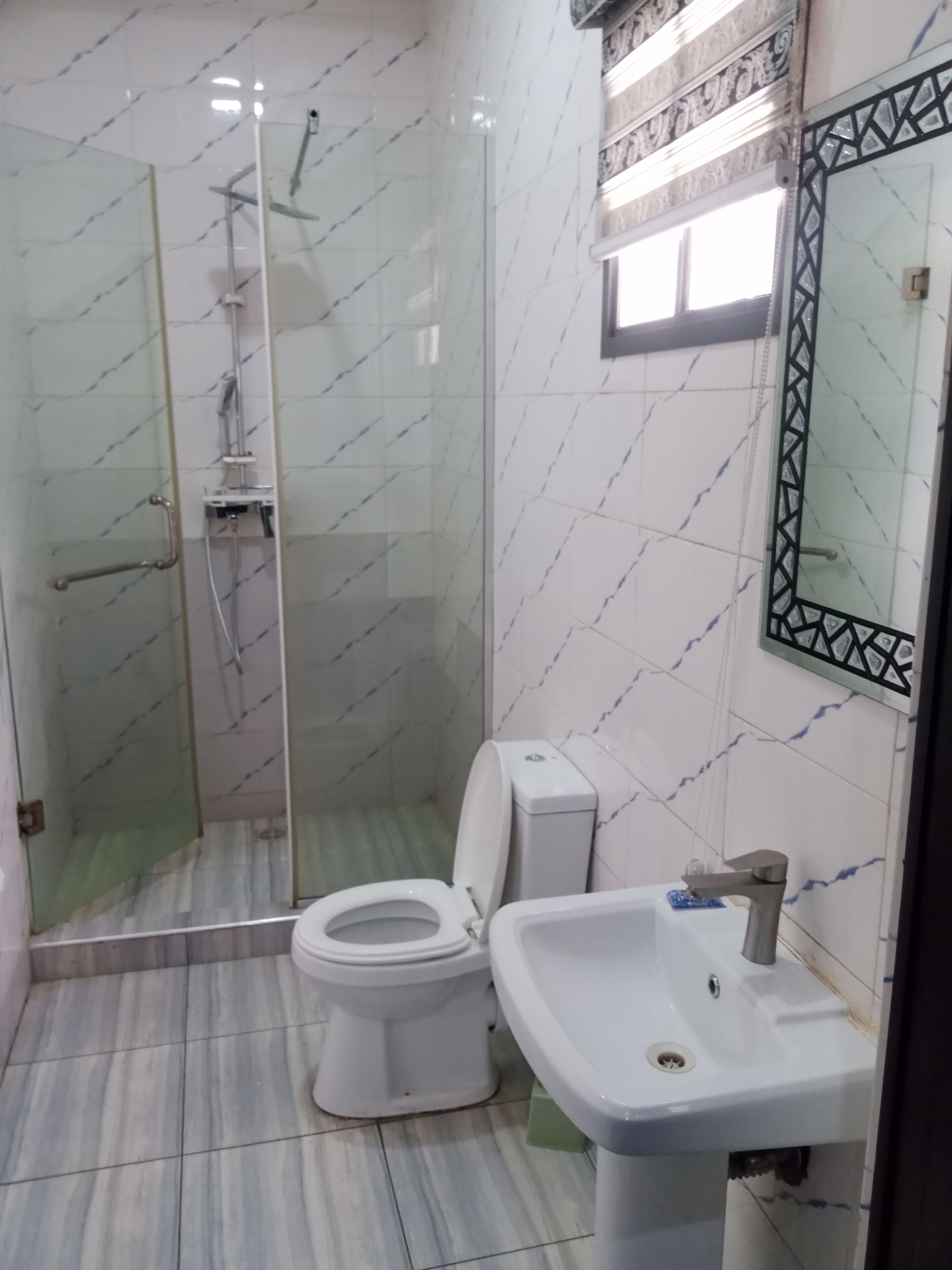 Ein Badezimmer mit Duschkabine, Toilette und Waschbecken.