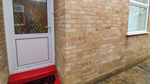 A red brick building with a white door and a window. - 5 Overstone Drive (Wisbech)