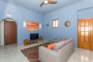 Ein Wohnzimmer mit einer Couch, einem Fernseher und Dekorationselementen.