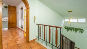 A staircase with a wooden handrail, a tiled floor, and a wall-mounted plant. - Apartment 'Lemon Terrace' with Private Terrace, Wi-Fi and Air Conditioning (Catania)