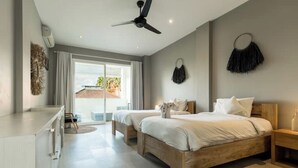 Ein modernes Hotelzimmer mit zwei Betten, einem Deckenventilator, einem großen Fenster mit Vorhängen und Blick ins Freie.