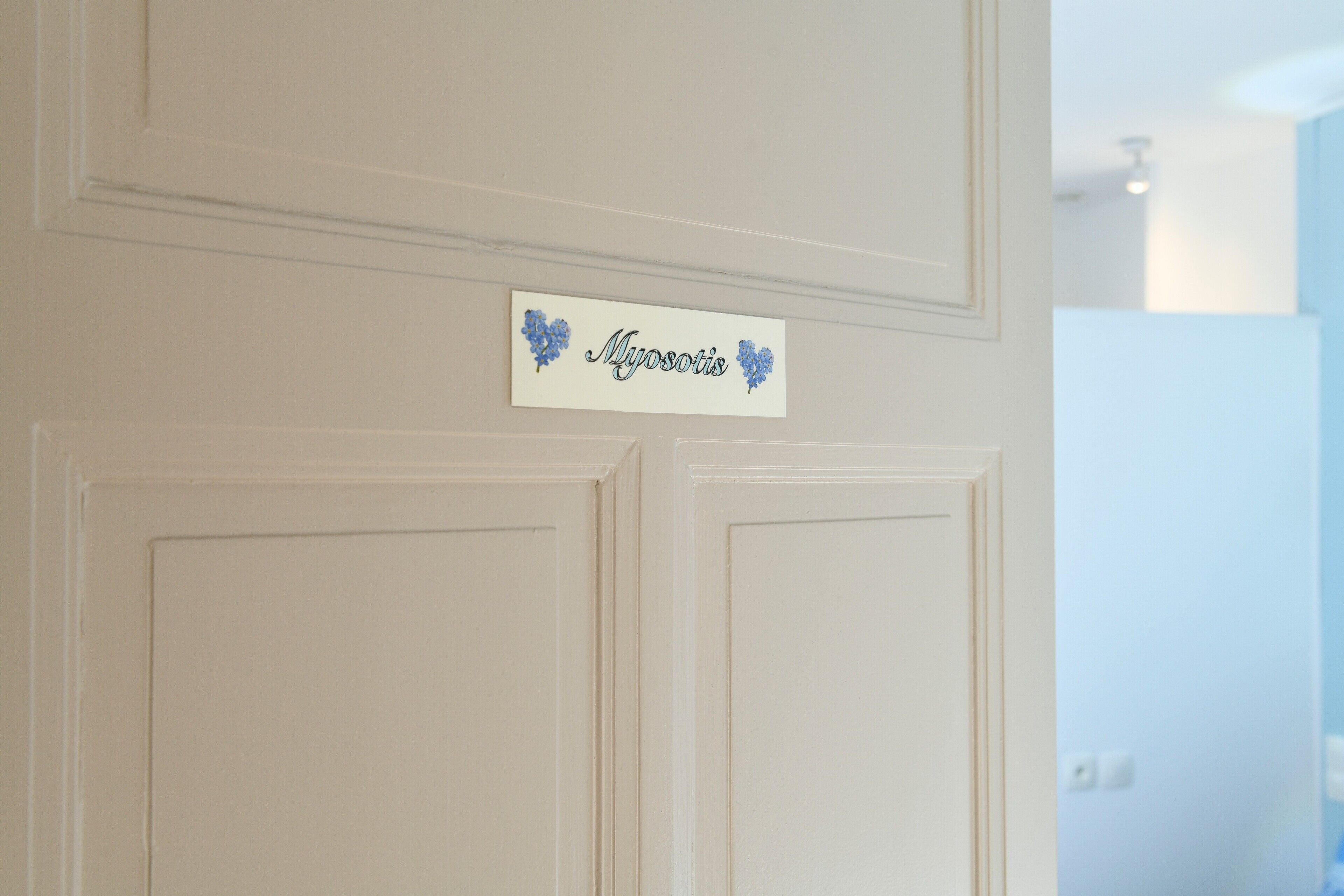 Uma porta branca com uma placa em cima.