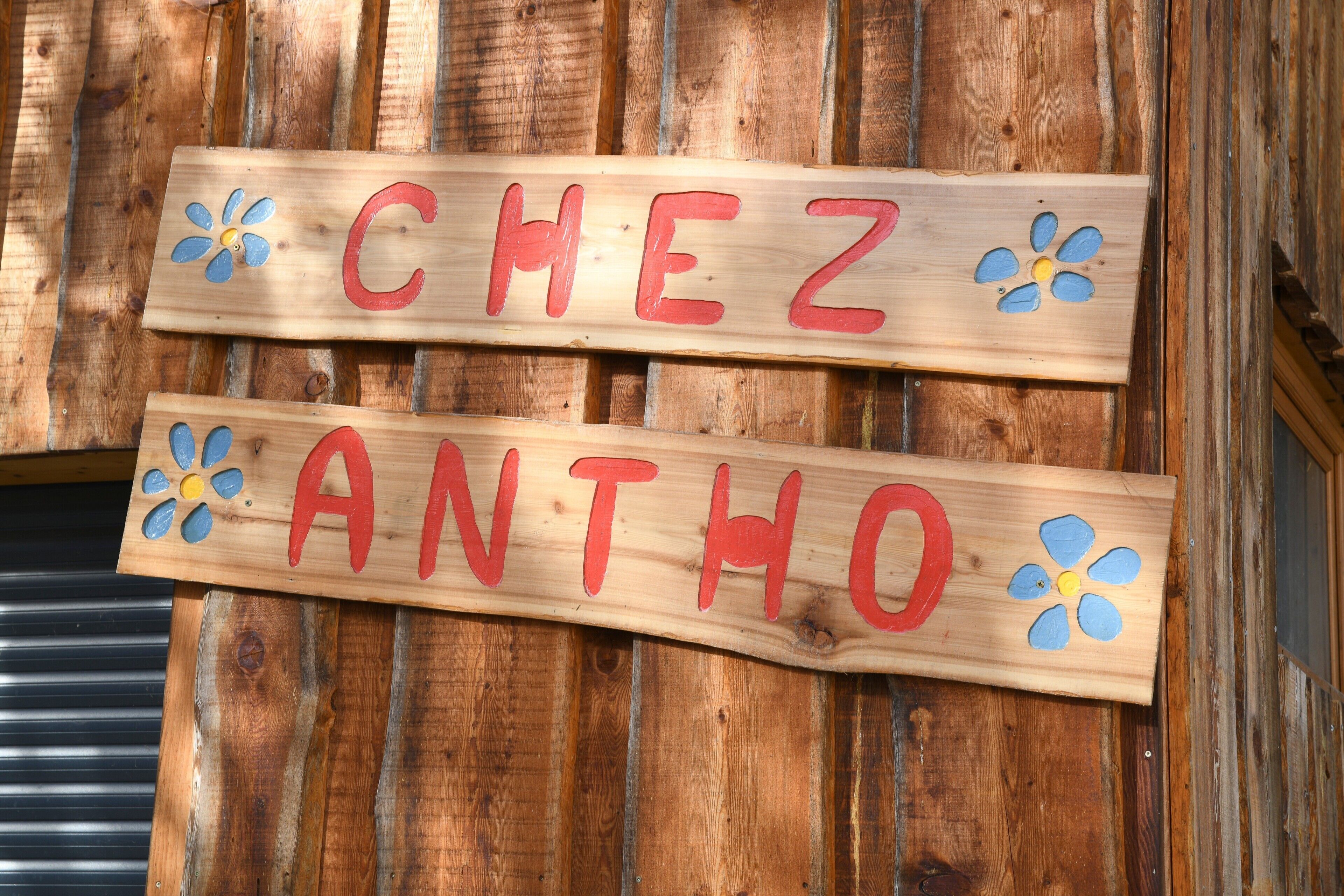 Twee houten borden met namen en decoratieve bloemen.
