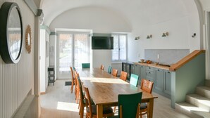 A spacious dining area with a long wooden table and chairs, a kitchen with a built-in island, and a staircase leading to an upper level. - Guest Room 4 with Shared Pool, Communal Garden, and Wi-Fi (Betton-Bettonet)