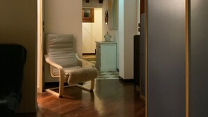 A hallway with a chair, a small table, and a refrigerator. - 'Ca' Molinetto' Apartment with Wi-Fi and Air Conditioning (Treviso)