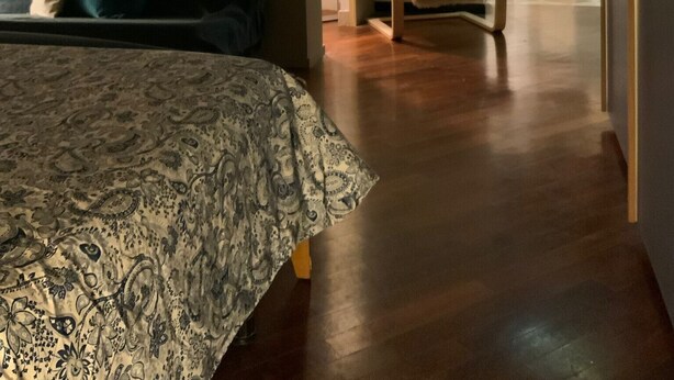 A bedroom with a bed, a chair, and a hallway leading to a bathroom. - 'Ca' Molinetto' Apartment with Wi-Fi and Air Conditioning (Treviso)