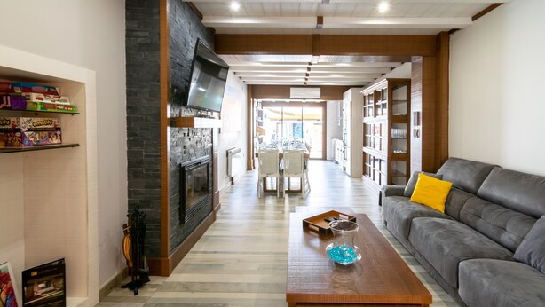 A modern living room with a fireplace, a sofa, a coffee table, and a bookshelf.