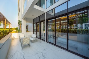 En modern byggnad med stora glasfönster, ett takförsett utomhusområde med sittplatser och ett vitt marmorgolv.