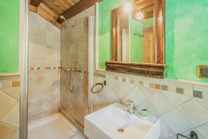 A bathroom with a shower, a sink, and a mirror. - La Cabaña - Rural House in Burgos: 5 Bedrooms and Mountain Views (Mozoncillo de Juarros)