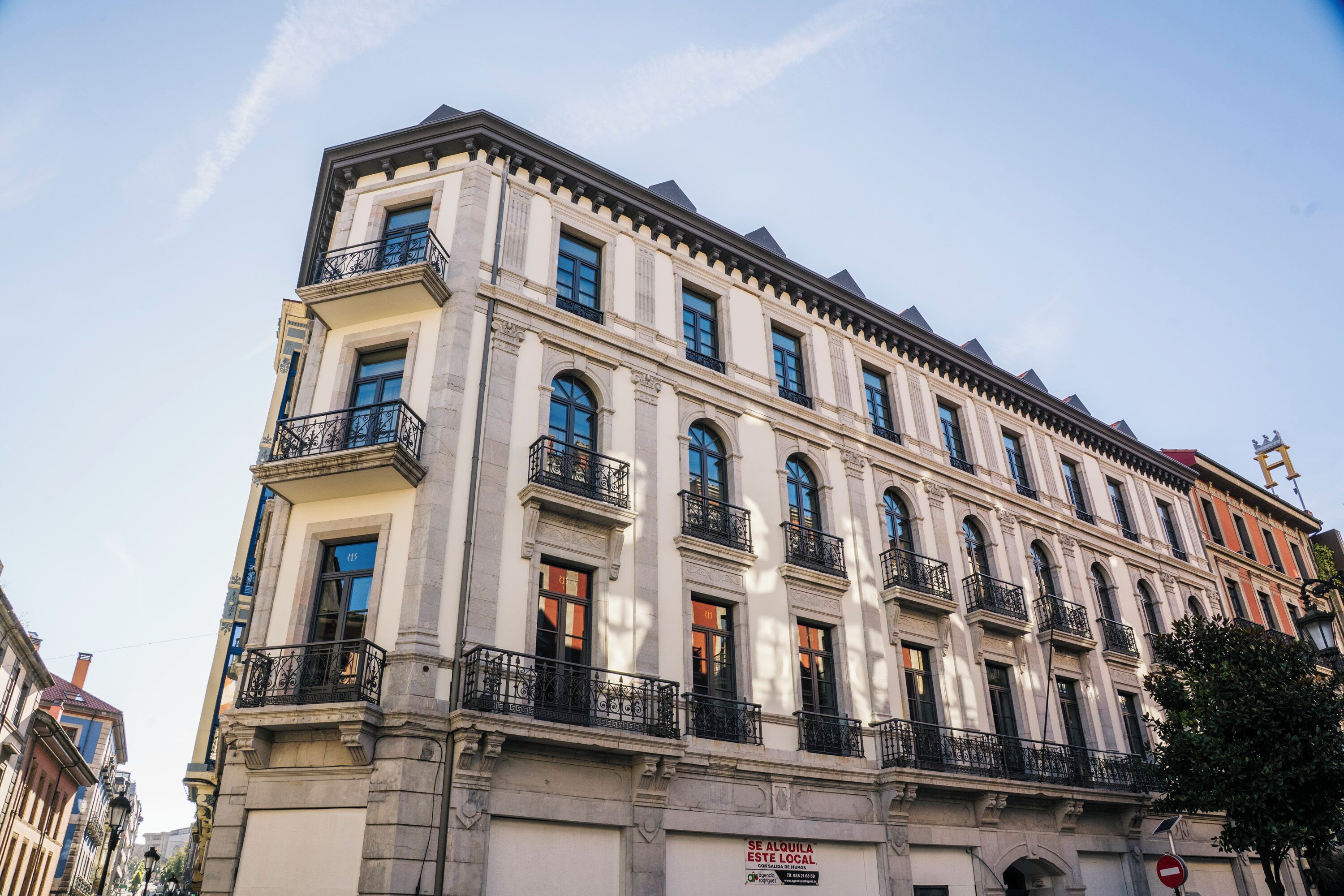 A multi-story building with classical architecture, featuring balconies and large windows.
