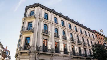 A multi-story building with classical architecture, featuring balconies and large windows.