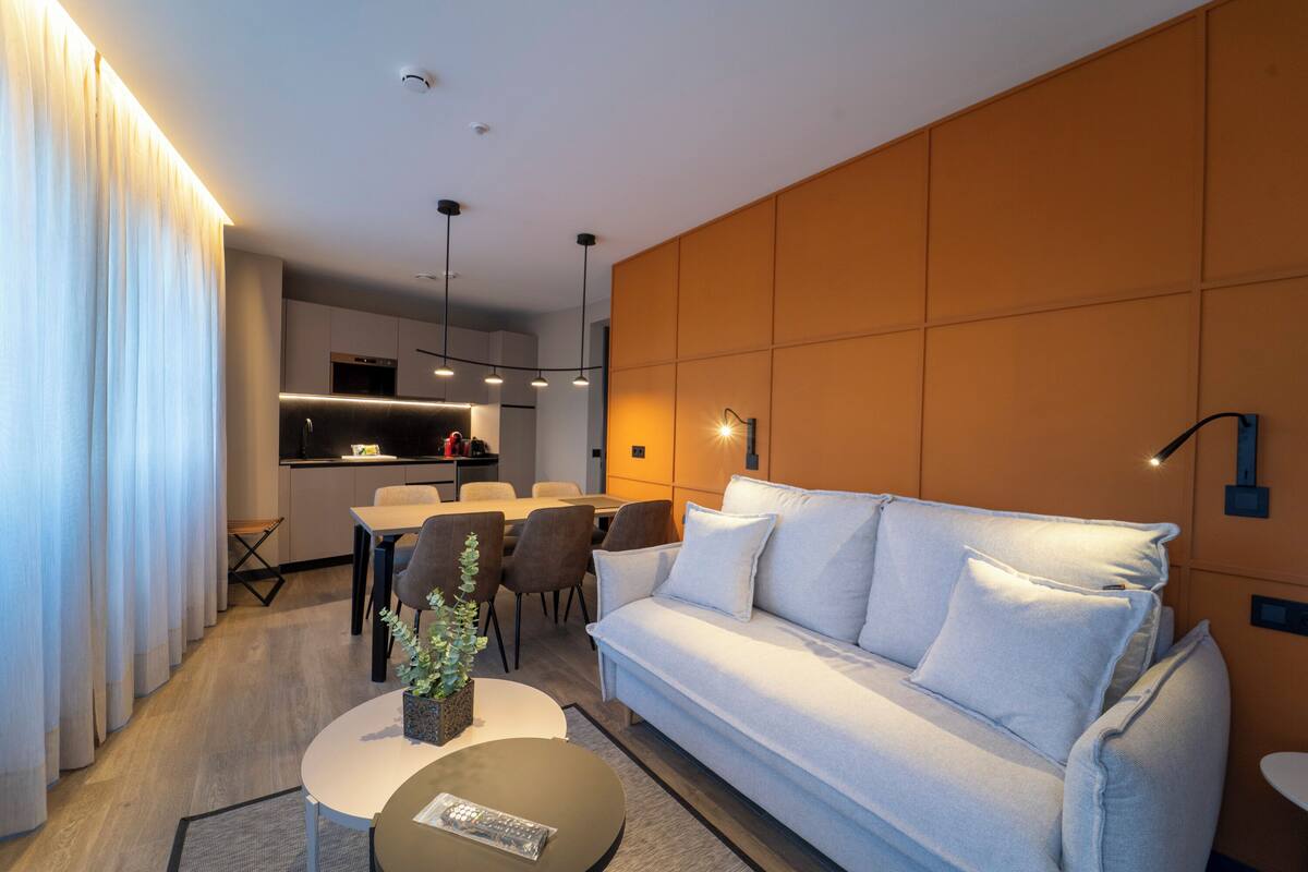 Una sala de estar moderna con sofá, mesa de centro y comedor.