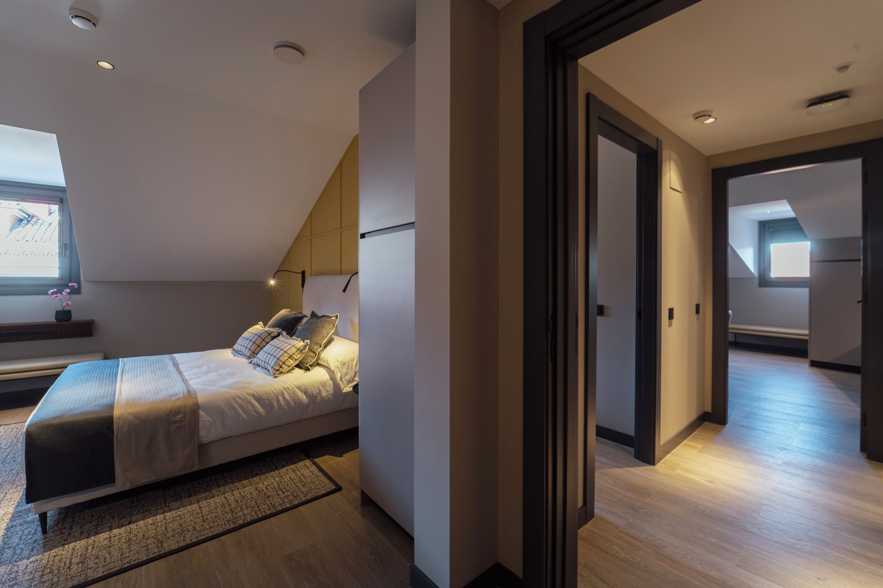 Une chambre à coucher moderne avec un lit, une table de chevet et une fenêtre.