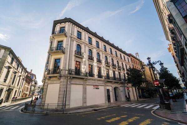 Un bâtiment historique à la façade classique, doté de plusieurs étages et situé à l’angle d’une rue.