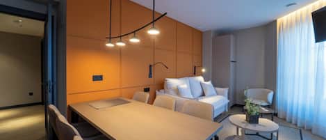Una habitación de hotel moderna con una cama grande, una mesa de comedor y un área de estar.