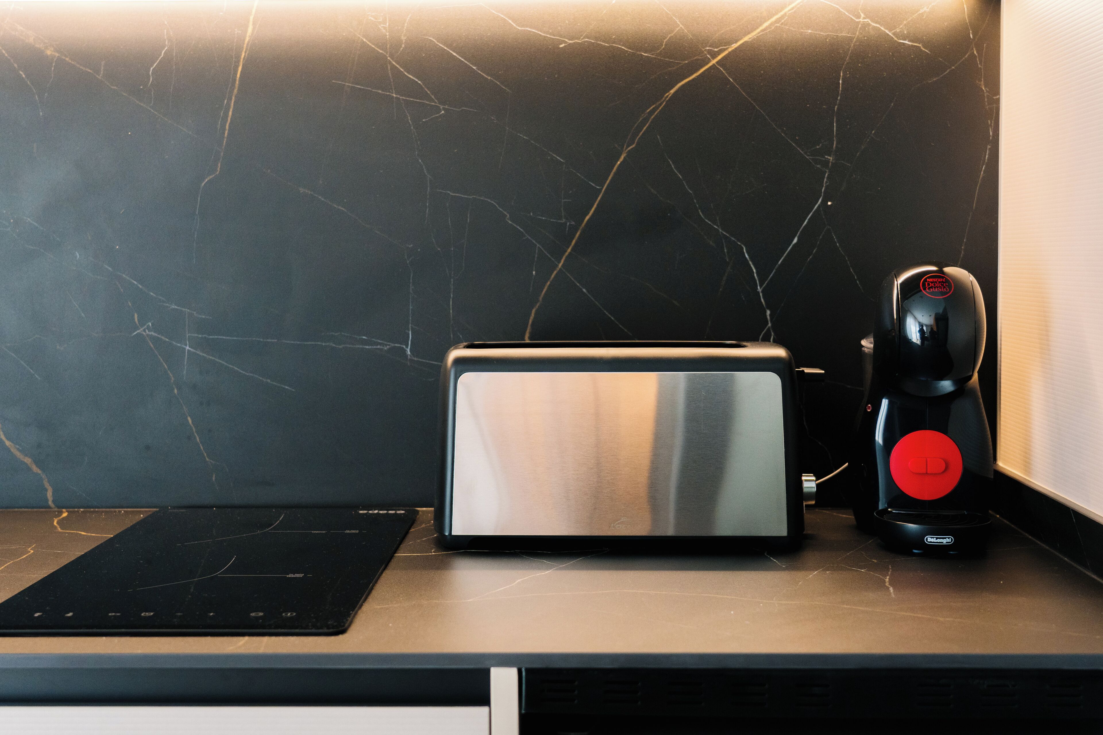 A kitchen counter with a toaster, a coffee maker, and a black electric kettle.