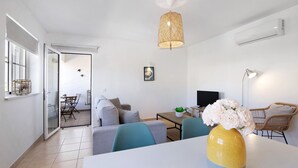 Een moderne woonkamer met een bank, een eettafel en een bloevas.