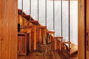 Una scala in legno rustica con una stufa d'epoca e un armadietto di legno.