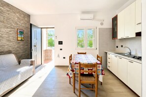 Eine moderne Küche mit Esstisch, Holzstühlen und einem eingebauten Backofen.