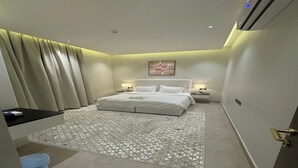 Un dormitorio moderno con una cama grande, mesitas de noche y una alfombra estampada.
