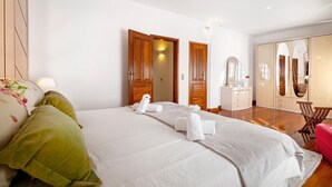 Une chambre d’hôtel avec un lit, un bureau, une chaise et une armoire.