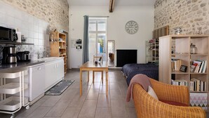 A compact living space with a kitchenette, dining area, and a cozy seating area.