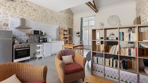 A kitchen with a microwave, oven, and a dining area with a table and chairs.