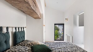A bedroom with a bed, a window, and a door. - Maison Bellecour: Shared Terrace, Garden & Wi-Fi in Vaudelnay (Vaudelnay)