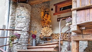 A rustic stone staircase with wooden steps, a metal bucket with a plant, and a decorative arrangement of paper flowers.