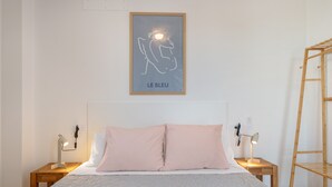 Una camera da letto con un letto, due comodini, una mensola a parete e un quadro incorniciato.