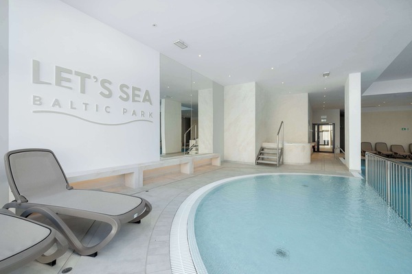 A spa relaxation area with a circular hot tub and comfortable loungers. Soft lighting and soothing décor create a calm atmosphere.