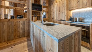 Een moderne keuken met houten kastjes, een granieten aanrechtblad en roestvrijstalen apparatuur.