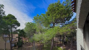 A courtyard with trees, a pathway, and a building with a balcony. - Bright T2 Apartment - 200m from Beach, 4 pax (Argelès-sur-Mer)