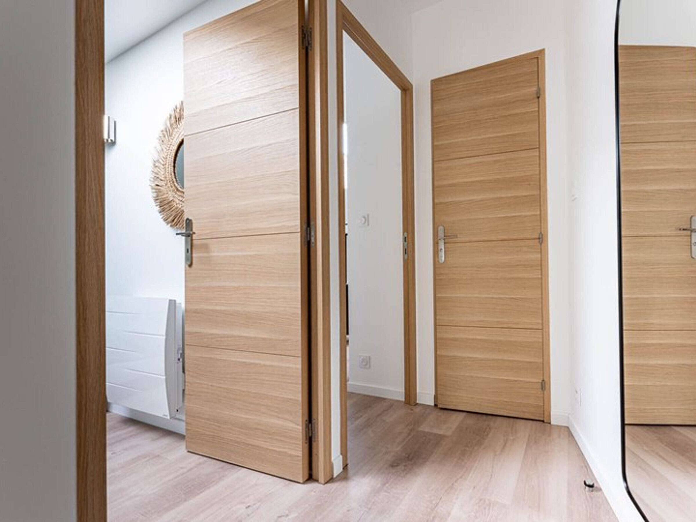 Ein Flur mit Holztüren und einem weißen Heizkörper.