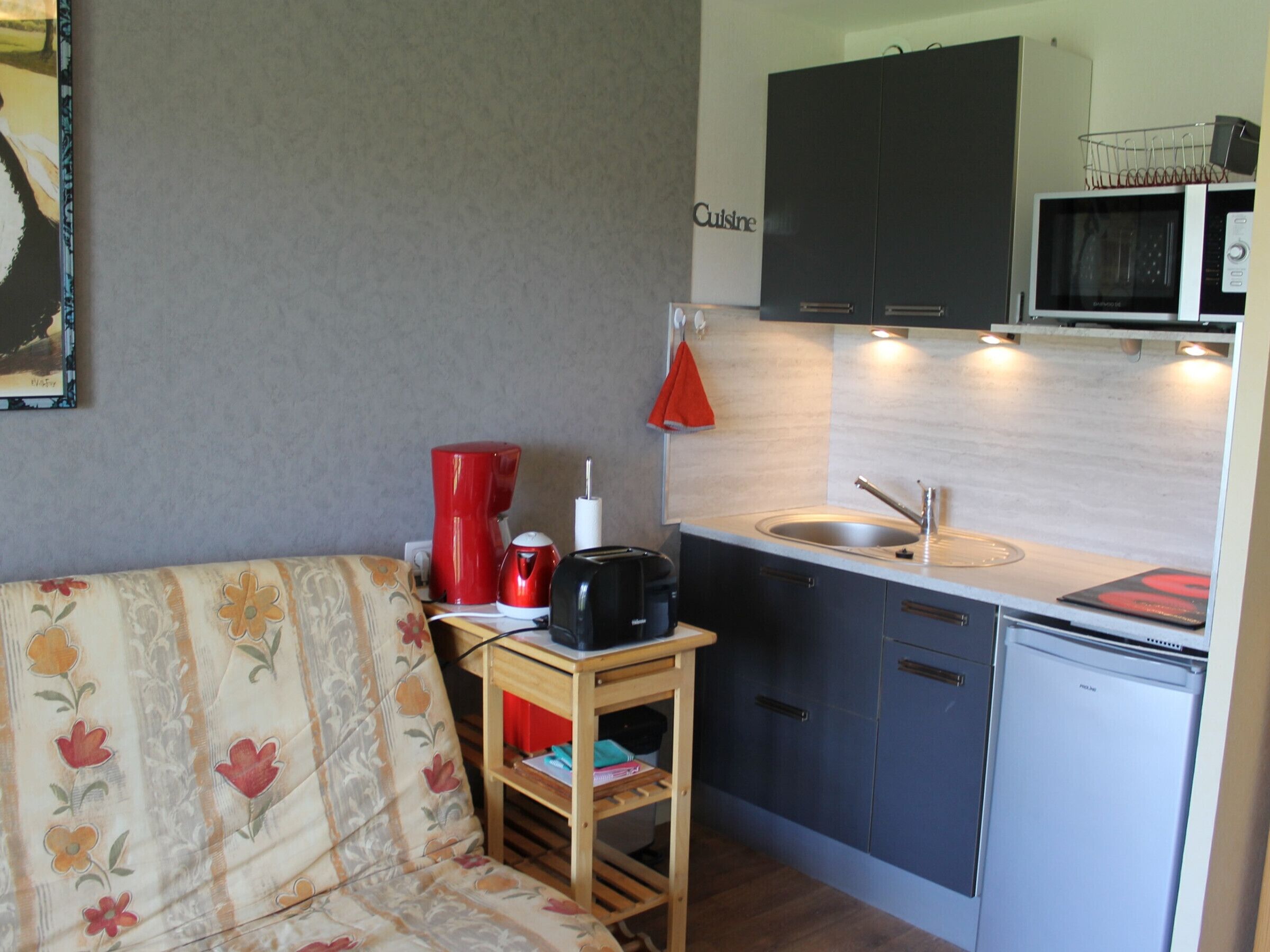 A compact kitchenette with a sink, microwave, and a small countertop.