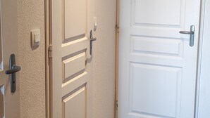 Three white doors with different designs, including a door with a handle and a door with a lock. - Calm apartment in Super Besse, 5 people, parking and pool (Besse-et-Saint-Anastaise-Super Besse)
