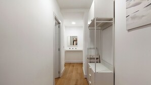 A narrow hallway with a wooden floor, white walls, and a white wardrobe with a mirror. - Amazing apartment in the centre of Seville (centro)