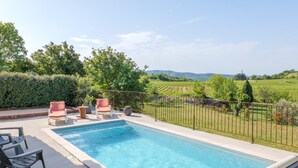 A rectangular swimming pool with a metal fence, surrounded by lounge chairs and potted plants. - Villa "Gîte Des Clapas – Lisa" with Wi-Fi and Air Conditioning (Balazuc)