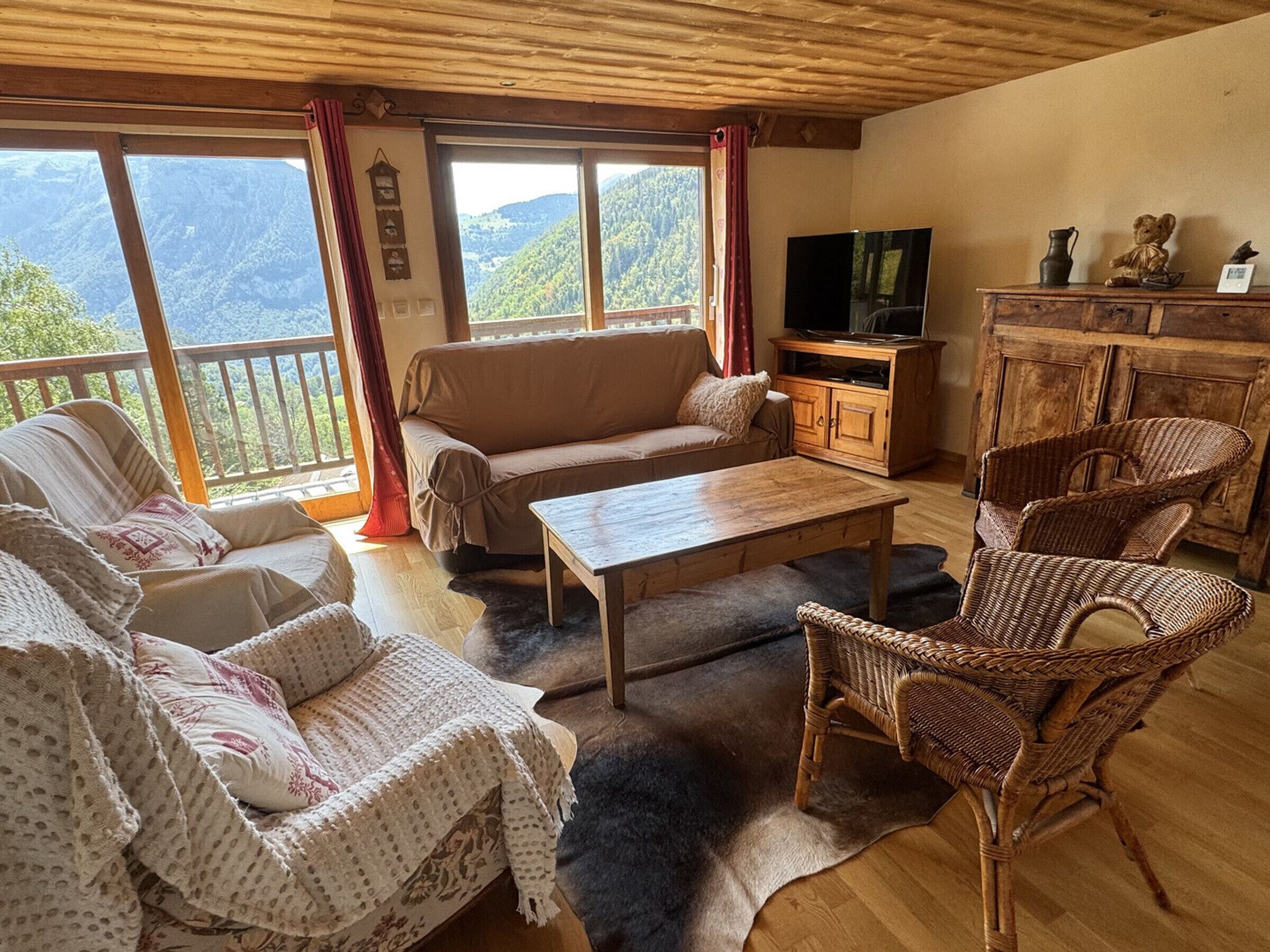 A cozy living room with a sofa, chairs, a coffee table, and a TV.