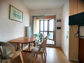 Ein Essbereich mit Holztisch und Stühlen, einem Fenster mit Jalousien und einem Schild an der Wand.