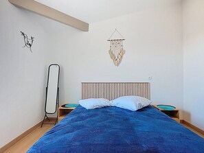 A bedroom with a bed, two bedside tables, a hanging light fixture, and a wall decoration. - 2-Bedroom Apartment for 6 Guests with Pool (Vieux-Boucau-les-Bains)