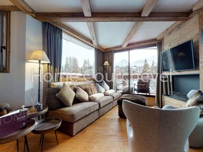 A cozy living room with a sofa, a coffee table, and a fireplace. - Courchevel 1850, 4 rooms, 8 ppl, ski-in/ski-out, parking (Courchevel)