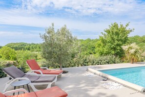 A poolside area with lounge chairs and a view of a lush landscape. - Villa Flora with Private Pool, Terrace, and Wi-Fi (Balazuc)