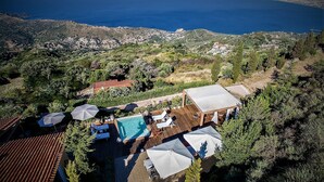 Ein Luftbild eines Anwesens mit Swimmingpool, Außenbereich zum Sitzen und Blick auf das Meer.