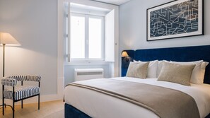 Una habitación de hotel con una cama, una silla, un ventanal y una obra de arte colgada en la pared.