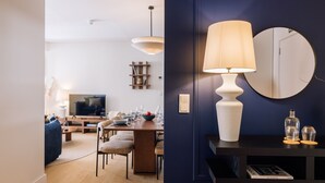 Una sala de estar moderna con televisor, comedor y una lámpara grande.