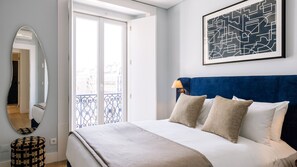 A bedroom with a bed, a mirror, a window, and a wall-mounted artwork. - Ando Living - Two Bedroom Superior Apartment (Lisbon)