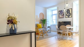 Ein modernes Wohnzimmer mit einer Couch, einem Couchtisch und einem Essbereich mit Stühlen.