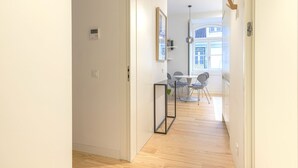 En hall med ett matområde som inkluderar ett bord och stolar, en hänglampa och ett fönster med utsikt.