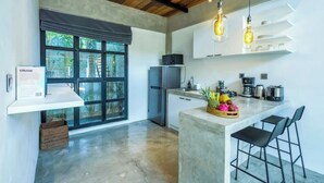 A modern kitchen with a large island, bar stools, and a refrigerator. - Urban Oasis Loft by GORO (Kabupaten Badung)